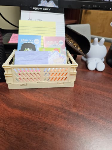 Customer's beige Foldable Storage Box sitting on a wooden desk, filled with colorful sticky notes and notepads.