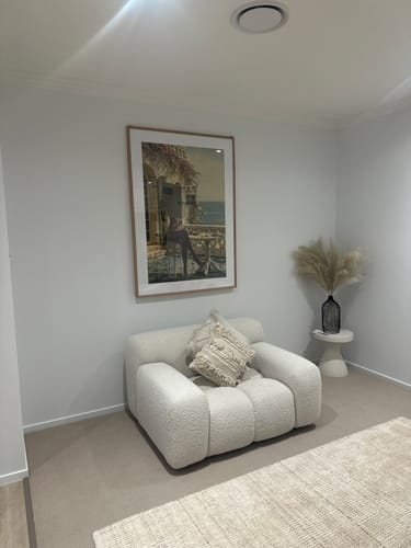 Reviewer's artwork, framed with the White Gallery Mat Board, hanging on a wall above a white armchair.