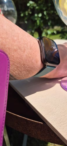 Customer wearing the replacement smartwatch with a dark green band on their wrist.