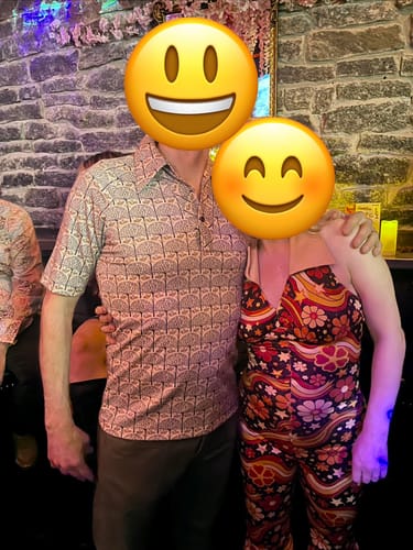 Reviewer wearing the colorful 70s patchwork halter jumpsuit at a themed party.