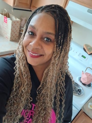 Customer smiling while wearing the Outre BOHO BOX BRAID 30" wig in a dark and creamy cappuccino color.