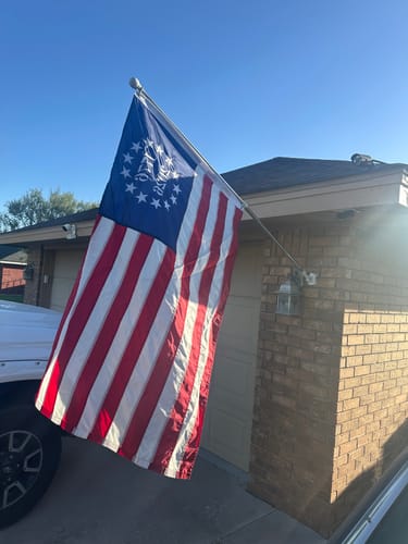 Customer's 1776 to 2026 Betsy Ross Flag flying on a flagpole attached to the side of a house.