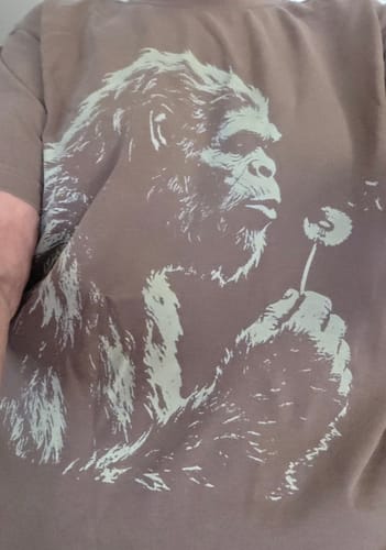 Reviewer wearing the brown Blowing Wishes T-Shirt, showing the Bigfoot and dandelion graphic.