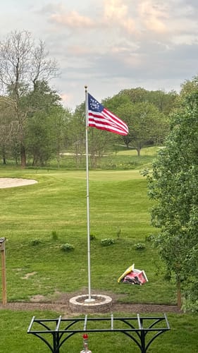 Reviewer's Betsy Ross Flag waving on a flagpole in a large, grassy yard.