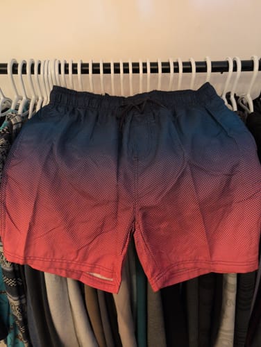 Customer's 80Eighty Fushion Shorts with a blue-to-red gradient pattern hanging on a rack.
