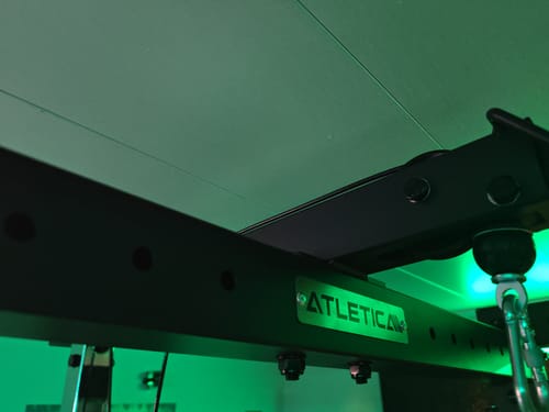 Rezensentenfoto: Nahaufnahme der schwarzen R7 Crossbar, bei der das Atletica-Logo von grünem Licht angestrahlt wird.
