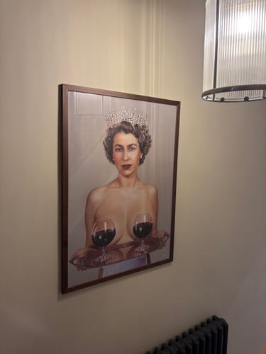 Customer's 'Majestic' framed art print of the Queen hung on a wall in their home.