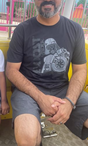 Customer wearing the black 80Eighty® BoostForce Shirt, showing how well the size fits while sitting on a ride.