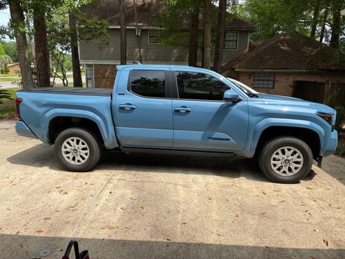 Customer's blue Toyota Tacoma parked in a driveway before installing the suspension lift kit, showing stock height.