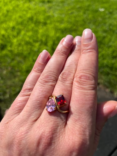 Customer wearing the Navae Birthstone Ring with a pink pear-cut and a red radiant-cut stone on their finger.