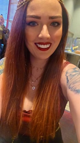 Reviewer smiling confidently, showing her bright white Pop On Veneers while attending a show.