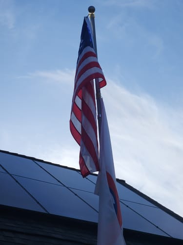 Customer's Betsy Ross Flag hanging on a flagpole against a blue sky.