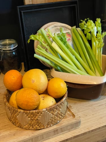 Kundenfoto zeigt den frischen Bio Stangensellerie in einer Schale, daneben Orangen und Grapefruits in einem Korb.