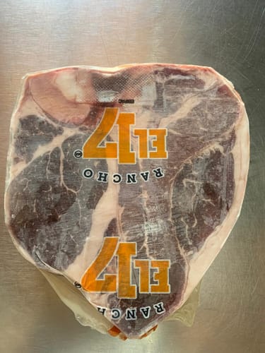 Cliente mostrando el Porterhouse Steak Corte Grueso, crudo y empacado al vacío.
