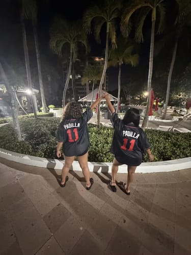 Customers seen from behind wearing matching custom Puerto Rico baseball jerseys with 'PADILLA' and the number '11' on the back.