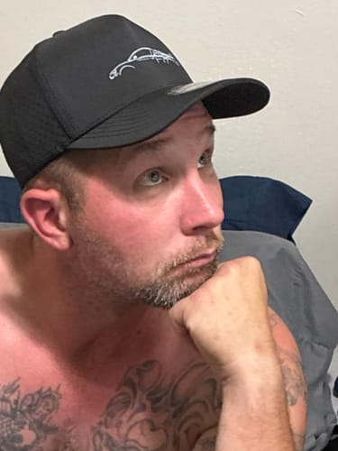 Close-up of a reviewer wearing the black 80Eighty® Limited Edition DCG89 Hat.