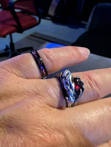 A customer's hand wearing the slender Solenox 4mm ring on the index finger next to another ring.