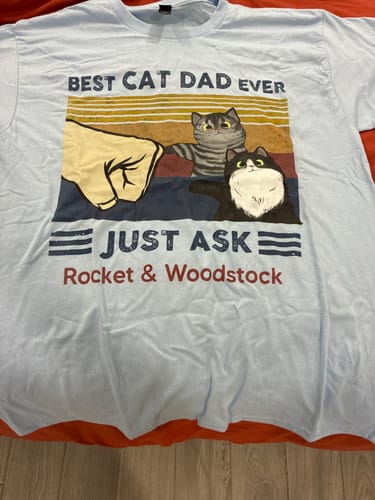 Customer's light blue personalized shirt with a "Best Cat Dad Ever" fist bump graphic featuring cats named Rocket & Woodstock.