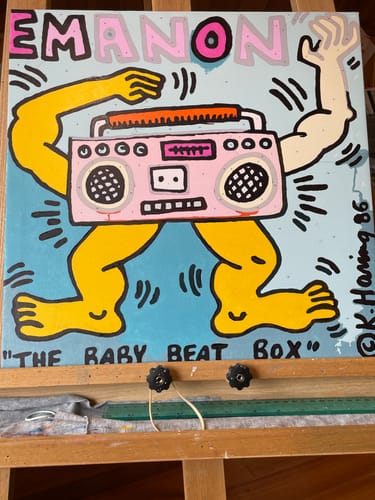 Customer's completed painting from their Custom Paint by Numbers Kit, a vibrant tribute to Keith Haring's art on an easel.