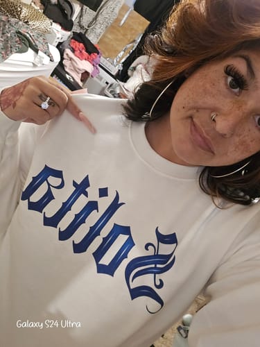Reviewer wearing the white Solita Art De La Calle Sweatshirt, pointing to the blue graphic on the chest.