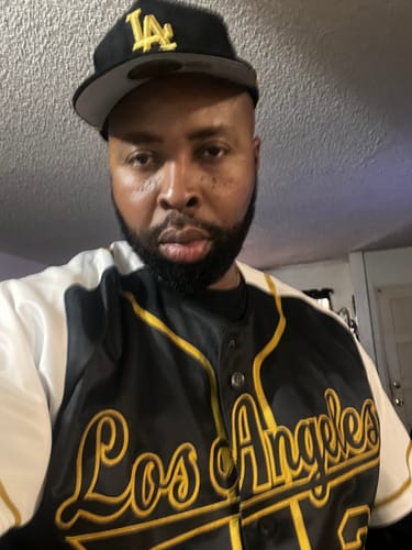 Reviewer wearing the custom black and gold raglan sleeve baseball jersey with 'Los Angeles' script.