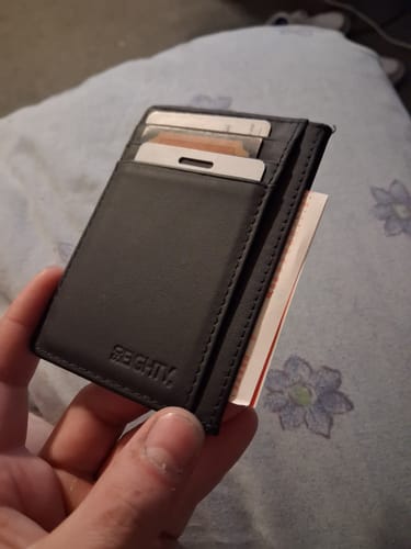 Customer holding the black 80Eighty® Leather Wallet, showing it filled with cards and cash.