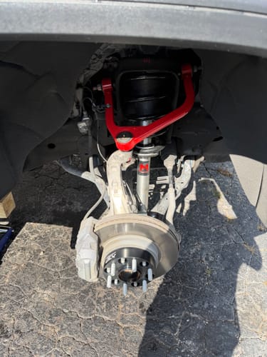 Customer's 1.5" Hubcentric Wheel Spacer installed on a truck's front hub with a red control arm.