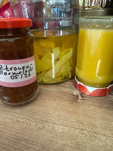 Rezensent zeigt Gläser mit selbstgemachter Zitronenmarmelade, Limoncello und Lemoncurd aus den Bio-Zitronen.
