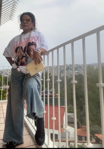 Cliente posando en un balcón con la camiseta Harry blanca, anudada a la cintura.