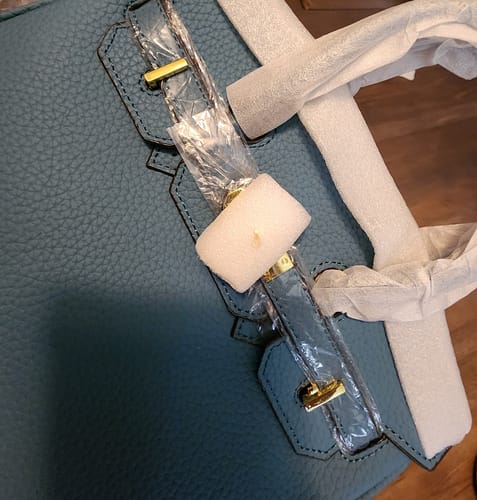 Customer's close-up of a new blue pebbled Warkin Bag with its hardware still wrapped.