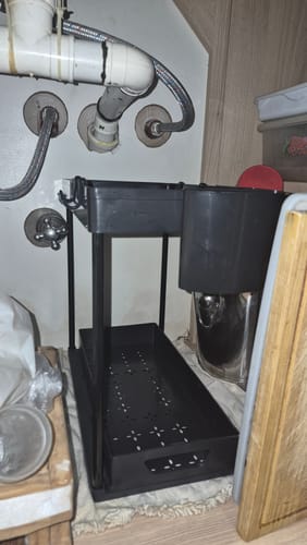 Un cliente muestra su organizador bajo mesada negro, instalado vacío bajo el fregadero.