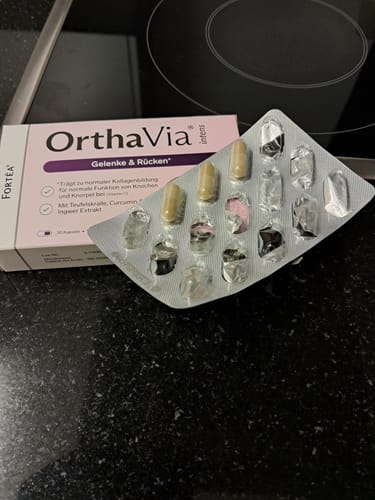 Ein Kunde zeigt die OrthaVia intens-Packung neben einer angebrochenen Blisterpackung mit Kapseln.