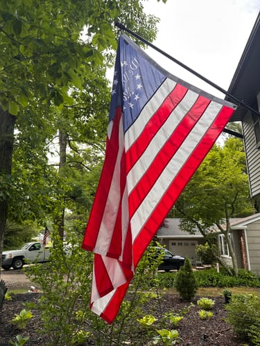 Customer's We The People Betsy Ross Flag hanging from a flagpole in a residential yard.
