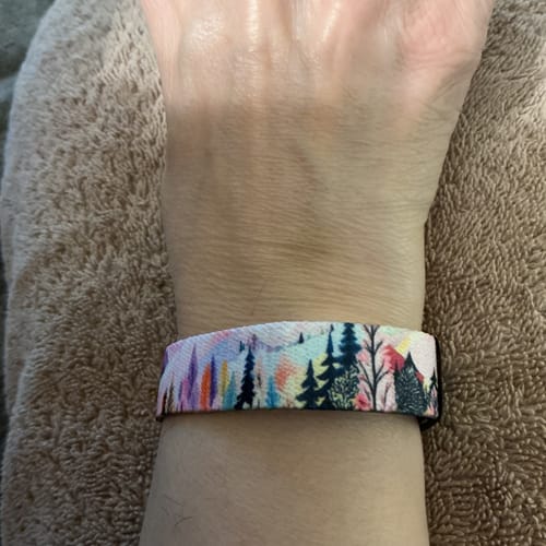 Customer wearing the You Deserve Happiness Bracelet, showing the colorful mountain and forest design on their wrist.