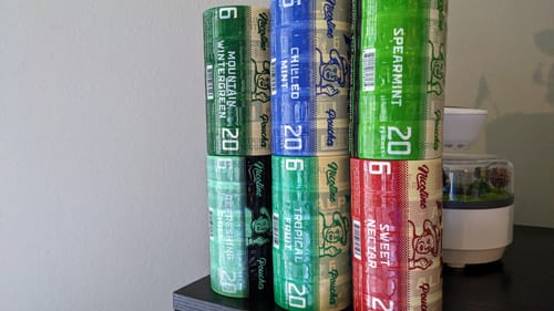 Reviewer's combo pack of nicotine pouches, showing stacked rolls of Sweet Nectar and other flavors.