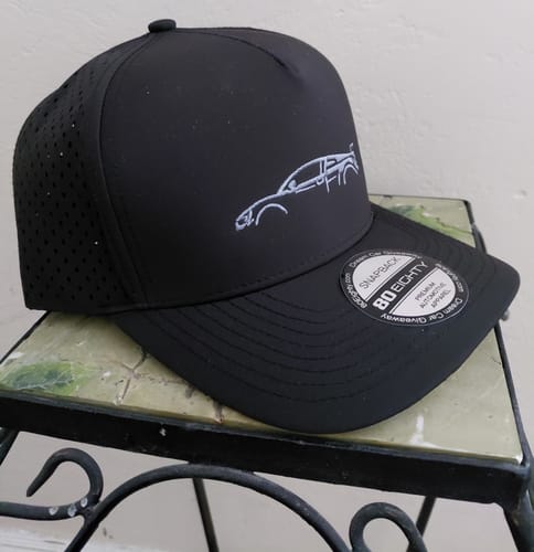 Customer's black DCG89 hat with a white embroidered car outline, showing the perforated material on its side.