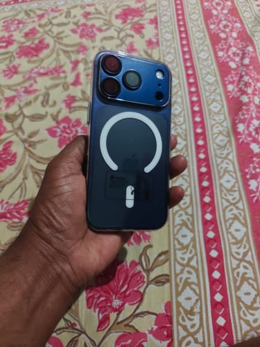 Reviewer holding a blue iPhone in the Anti Yellow Magsafe Clear Case, showing the back with the white magnetic ring.