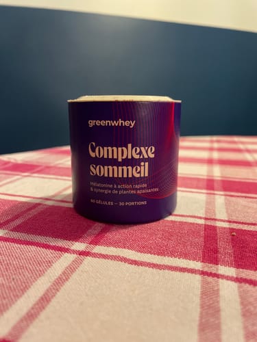 Photo d'un client montrant le pot violet de Complexe Sommeil sur une nappe à carreaux.