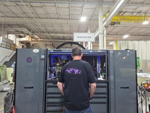 Customer seen from behind wearing the black 80Eighty® Limited Edition DCG88 Shirt with a purple car graphic.
