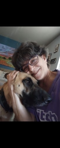 Customer photo for the Always By Your Side Bracelet review shows a person warmly hugging their German Shepherd.