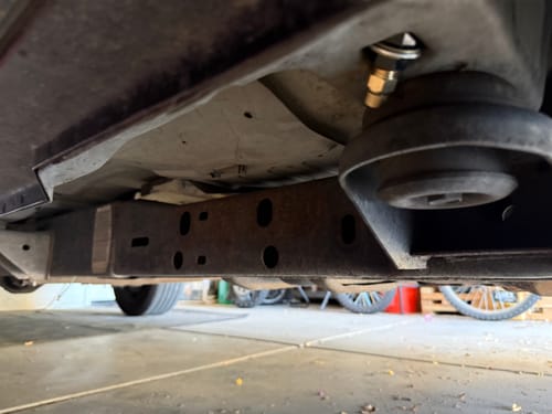 Customer's view of the Remote Catch Can Drain Kit installed on the undercarriage of their truck.