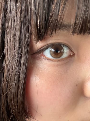 お客様による「Dewy Kristin 1Day - ブラウン」を装用した目元の写真。瞳が自然な明るいブラウンに見えます。
