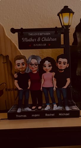 Customer's personalized 2-layered wooden plaque showing a family of four under a lamppost with names on the base.