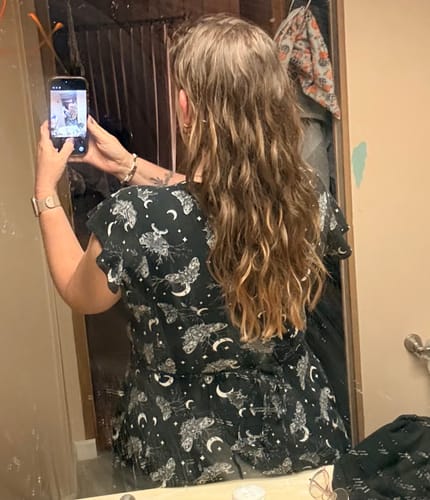 Reviewer from behind showing their long, wavy hair after using the Ocean Hair Texture Treatment.