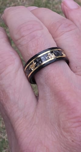 Customer's hand wearing the Titanfall ring, showing the black band with meteorite and gold flake inlay.