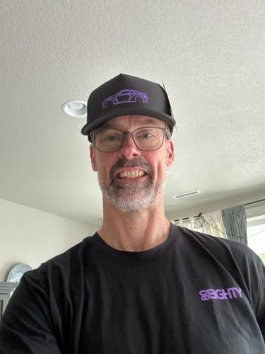 Customer wearing the black 80Eighty® Limited Edition DCG88 Hat with a purple car outline.