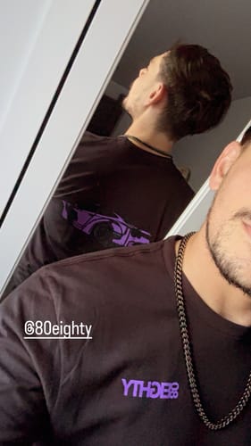 Reviewer in a mirror selfie wearing the black 80Eighty DCG88 Shirt, showing the back's purple graphic.