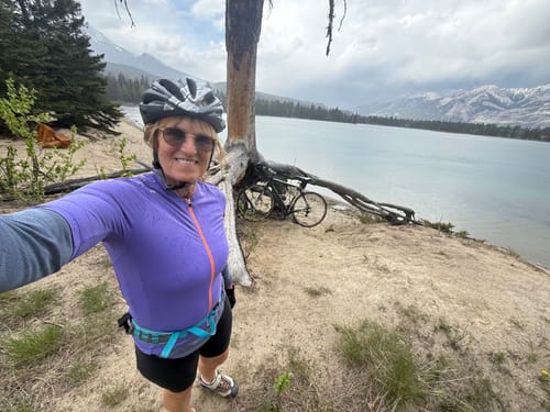 Reviewer in the purple Vividness Jersey taking a selfie during a bike ride by a lake.