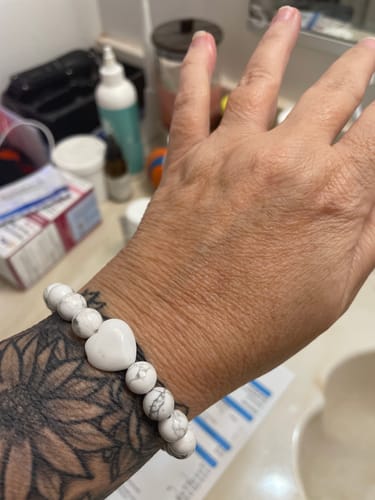 Customer wearing the white Howlite crystal bracelet with a heart stone on their wrist.