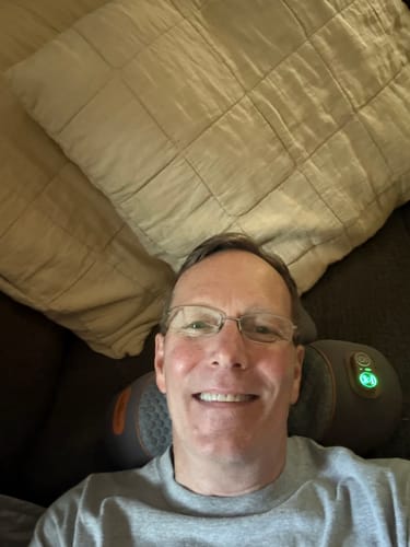 Customer relaxing with the RESTORE neck pillow
